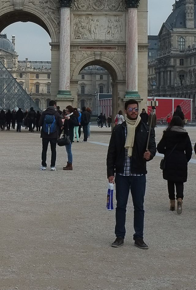 guy with selfie stick in front of the lourve