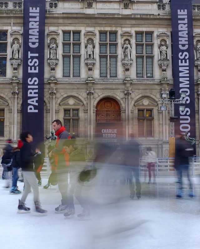 Blurry Skaters in front of Charlie Hebdo banner