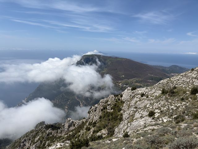 High on mountain looking down to another wrapped in cloud